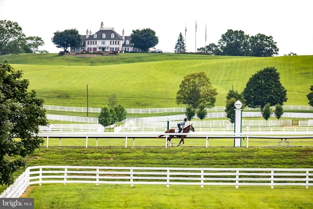 view of home's community featuring fence, a rural view, and a lawn