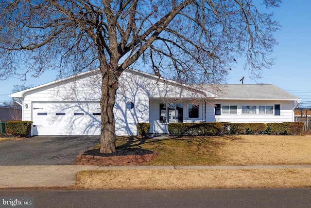 view of front of property with driveway, an attached garage, and a front lawn