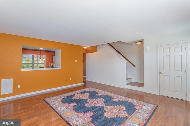 interior space with visible vents, baseboards, wood finished floors, and stairway