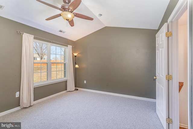 carpeted spare room featuring vaulted ceiling, baseboards, visible vents, and ceiling fan