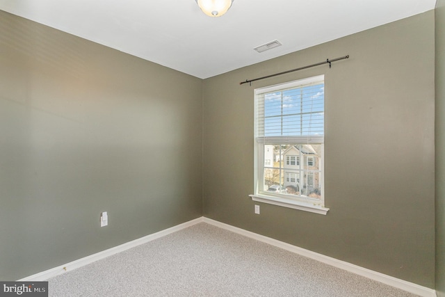 spare room featuring visible vents, carpet, and baseboards