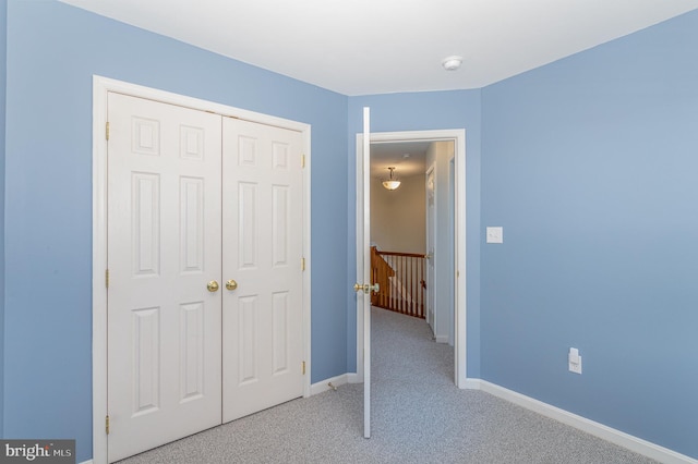 unfurnished bedroom with baseboards, a closet, and carpet floors