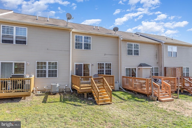 back of house with a deck, a lawn, and central AC