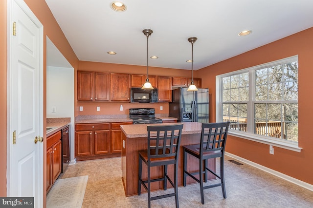 kitchen with visible vents, brown cabinets, black appliances, and light countertops