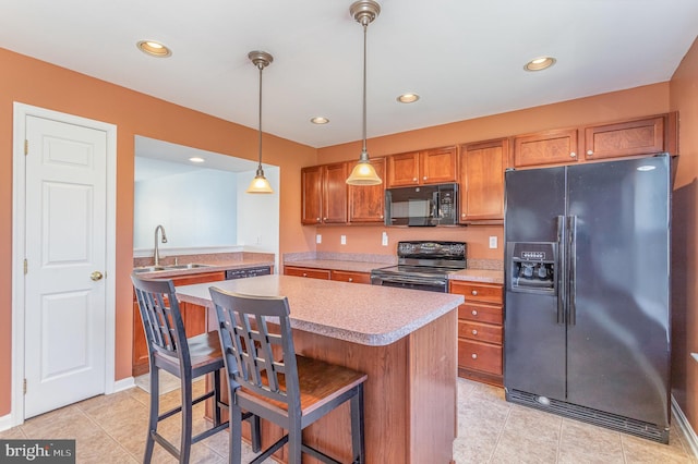 kitchen with brown cabinetry, a kitchen island, a sink, black appliances, and light countertops