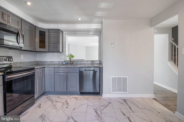 kitchen featuring light stone counters, visible vents, baseboards, and appliances with stainless steel finishes