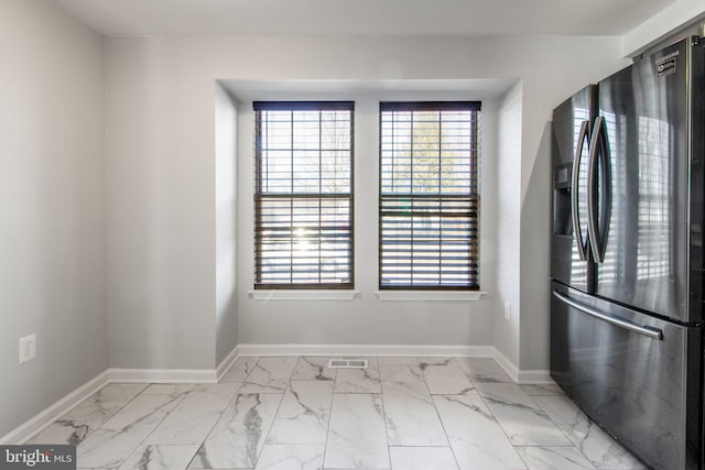 interior space featuring plenty of natural light, visible vents, marble finish floor, and baseboards