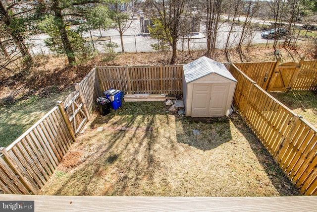 view of yard with a storage shed, a fenced backyard, and an outdoor structure