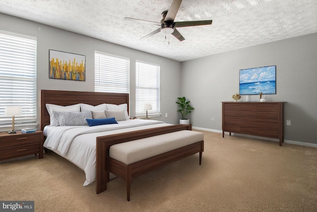 bedroom with baseboards, light carpet, and a textured ceiling