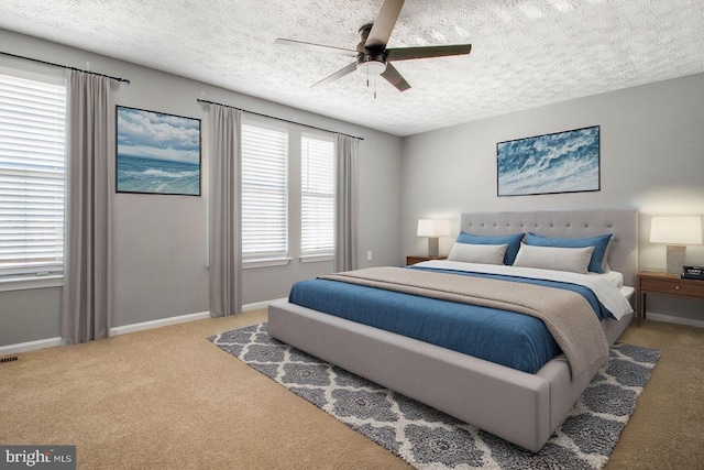 bedroom with carpet flooring, a ceiling fan, baseboards, and a textured ceiling