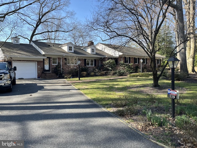 cape cod home with a front yard, brick siding, an attached garage, and driveway