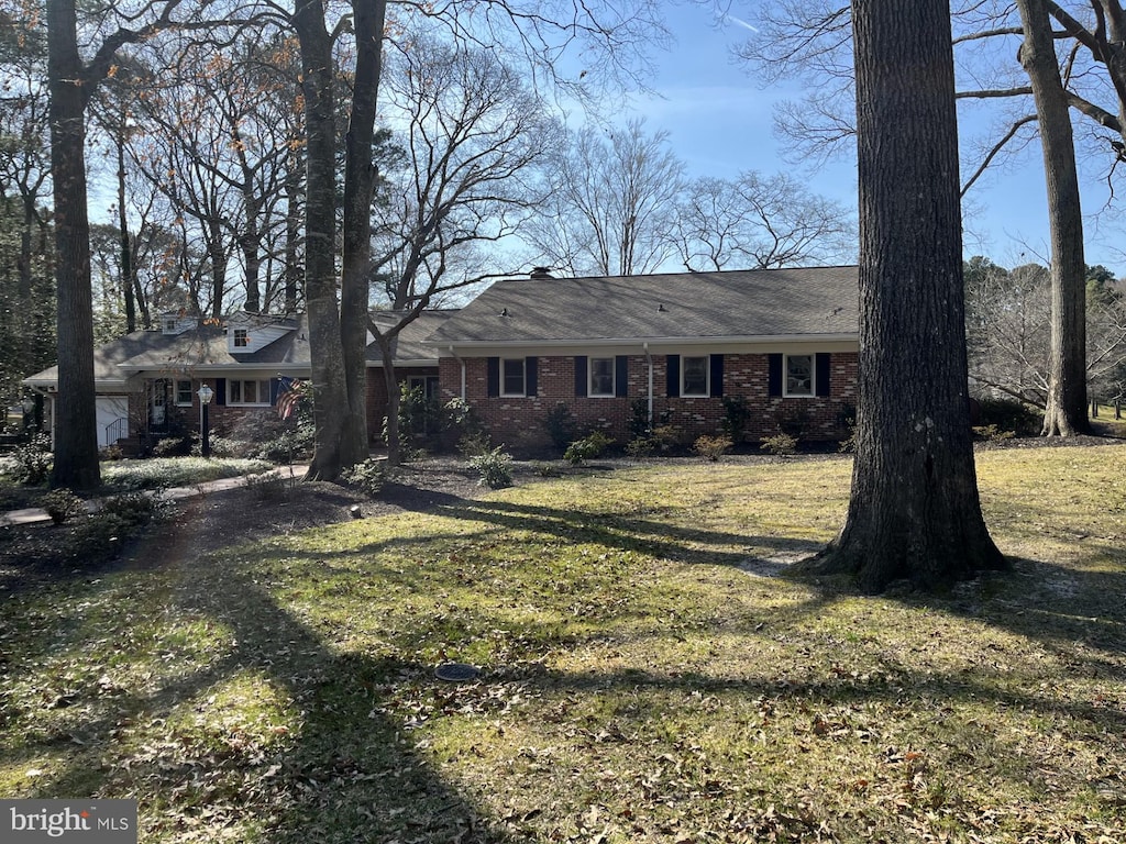 view of front of house with brick siding and a front yard