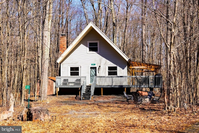 rear view of house with a chimney and a deck