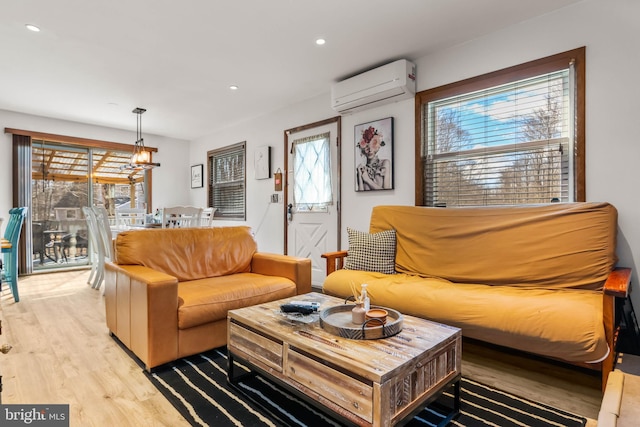 living room featuring recessed lighting, light wood-type flooring, and a wall unit AC