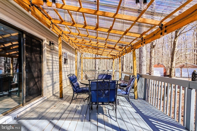 wooden terrace featuring outdoor dining space and a pergola