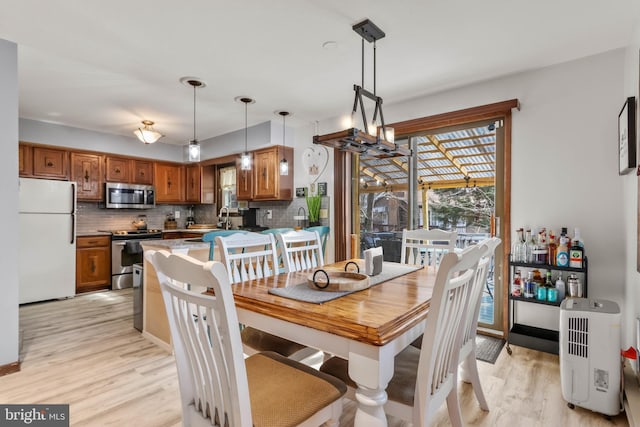 dining area with an inviting chandelier and light wood finished floors