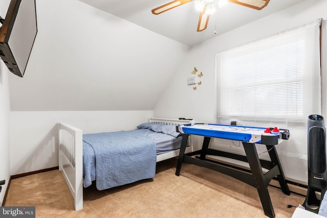 carpeted bedroom with ceiling fan, baseboards, and lofted ceiling