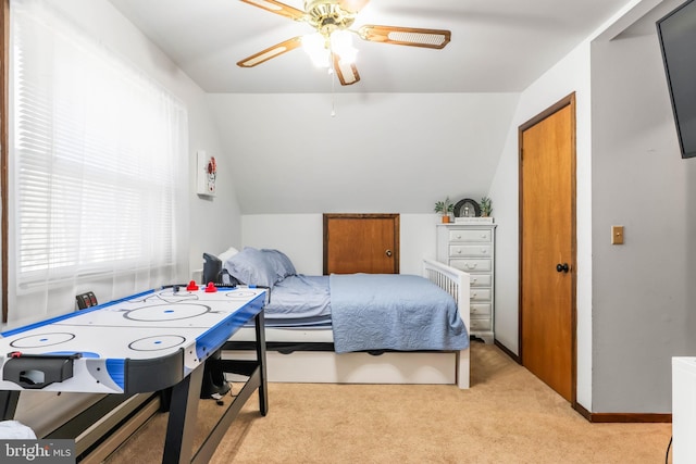 bedroom featuring a ceiling fan, vaulted ceiling, light colored carpet, and baseboards