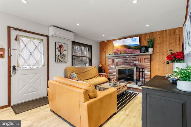 living room with light wood finished floors, wood walls, and an AC wall unit