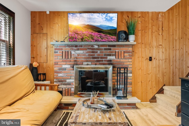 living room with wooden walls and a brick fireplace