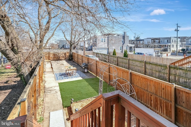 view of yard featuring a residential view, a patio, and a fenced backyard