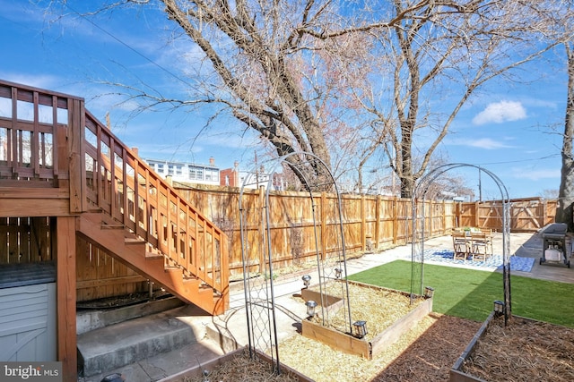 view of yard featuring stairs, a patio, a vegetable garden, and fence private yard