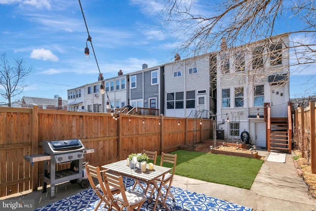 view of patio with area for grilling, fence, and a residential view