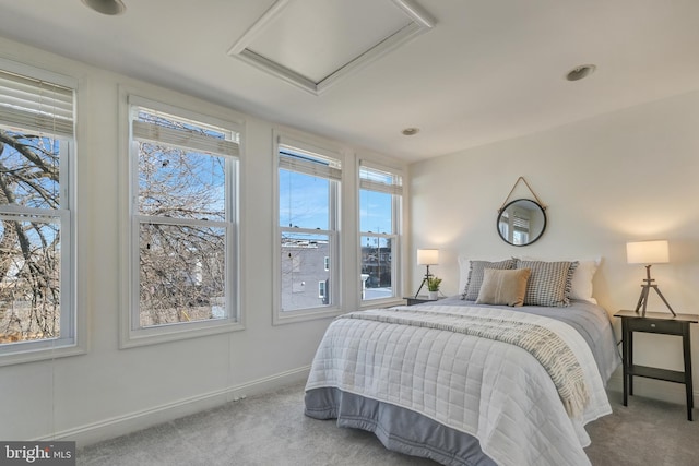 carpeted bedroom with attic access and baseboards