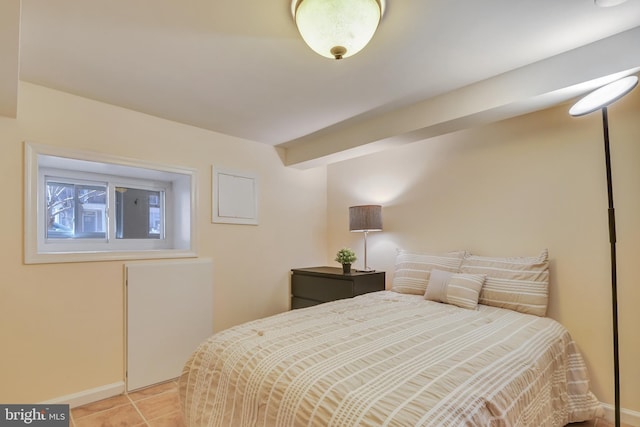 bedroom with light tile patterned flooring and baseboards