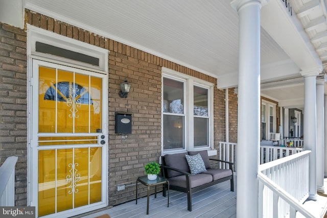 entrance to property featuring brick siding and a porch