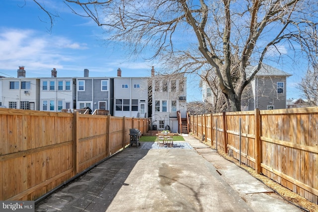 view of patio / terrace with grilling area, a residential view, and a fenced backyard