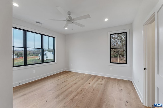 spare room with light wood finished floors, plenty of natural light, recessed lighting, and baseboards