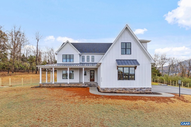 modern farmhouse style home with a standing seam roof, covered porch, and metal roof