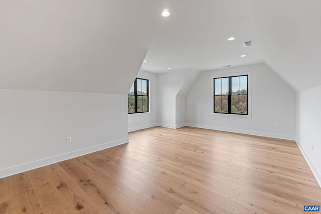 additional living space featuring light wood finished floors, baseboards, visible vents, and a wealth of natural light