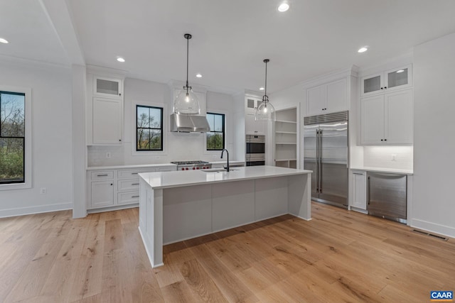 kitchen featuring visible vents, a sink, light countertops, under cabinet range hood, and appliances with stainless steel finishes