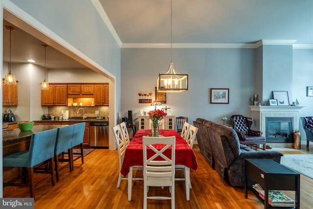 dining room with a notable chandelier, wood finished floors, and ornamental molding