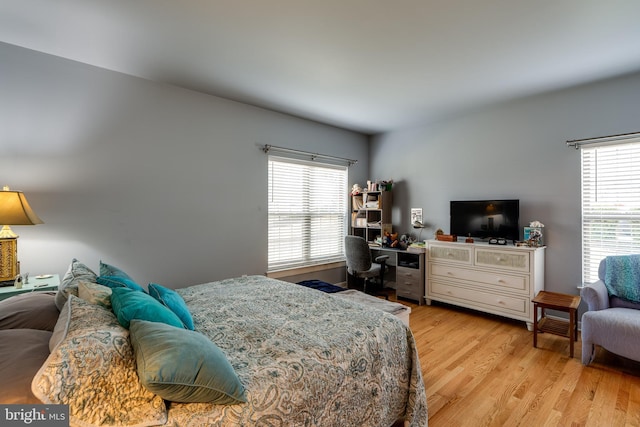 bedroom featuring multiple windows and light wood-style flooring