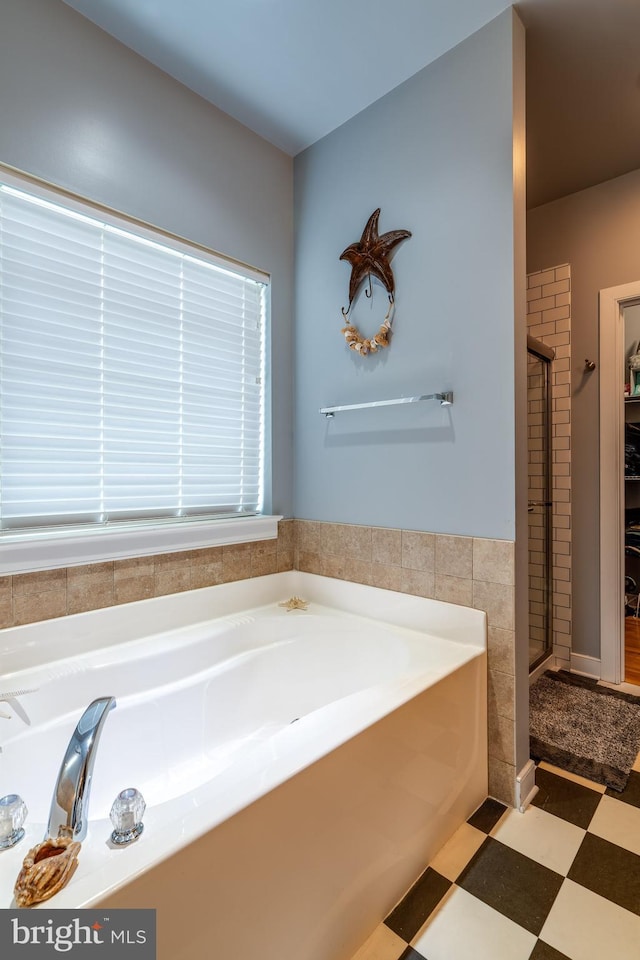 bathroom featuring tile patterned floors, a stall shower, and a garden tub