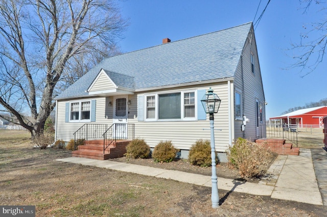 bungalow-style house featuring a chimney and a shingled roof