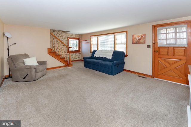 carpeted living area featuring visible vents, stairs, and baseboards