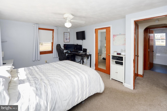 bedroom featuring ensuite bath, light colored carpet, and ceiling fan