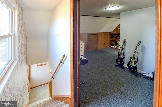 interior space with carpet flooring, baseboards, and lofted ceiling