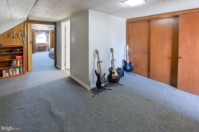 workout room with baseboards, carpet floors, and lofted ceiling