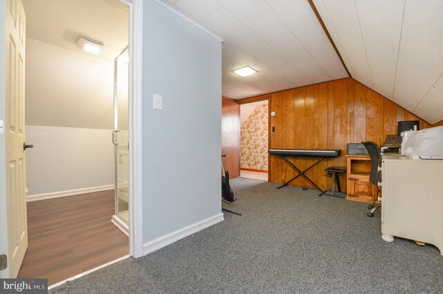 bonus room with baseboards, carpet, wooden walls, and vaulted ceiling