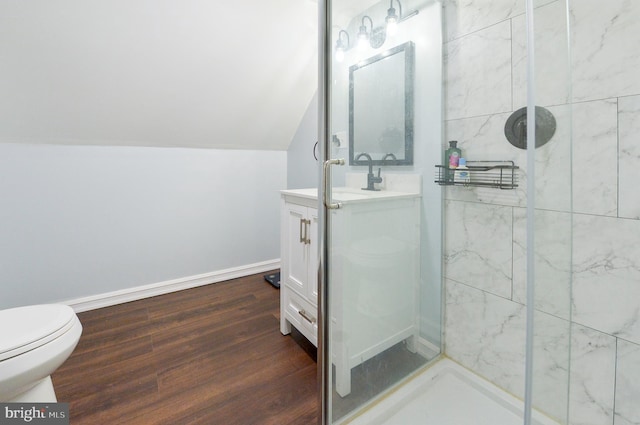 full bathroom featuring baseboards, toilet, a stall shower, wood finished floors, and vanity