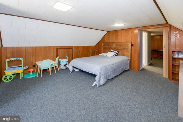 bedroom with carpet flooring, wood walls, and vaulted ceiling