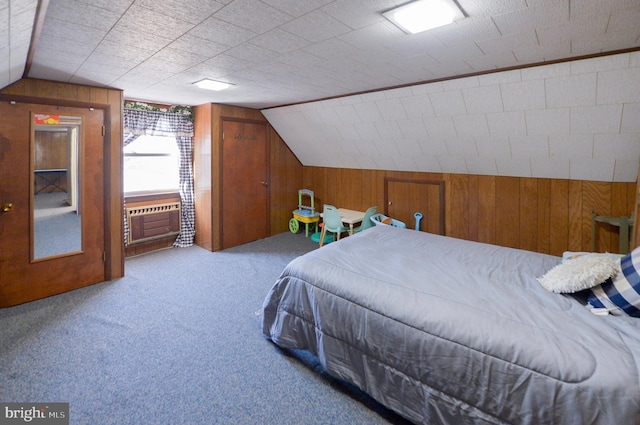 carpeted bedroom featuring cooling unit, wood walls, and vaulted ceiling