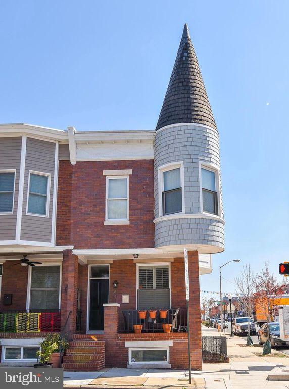 view of front of house featuring brick siding and a porch