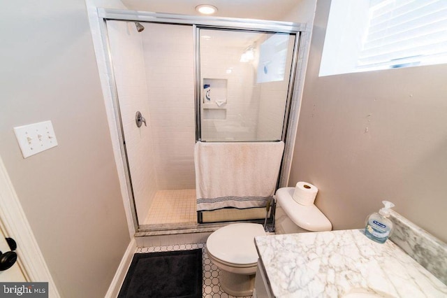 full bath featuring toilet, a stall shower, and vanity