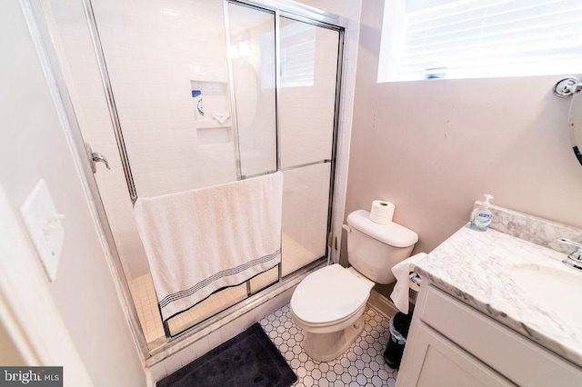 full bathroom featuring toilet, a stall shower, and vanity